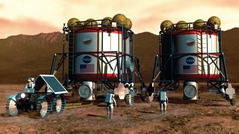 Astronauts in spacesuits work around two cylindrical habitat modules and a rover on a rocky, Martian-like landscape.