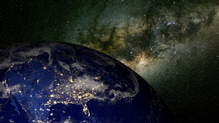 A view of Earth from space with illuminated city lights on the dark side, set against a backdrop of the Milky Way galaxy.