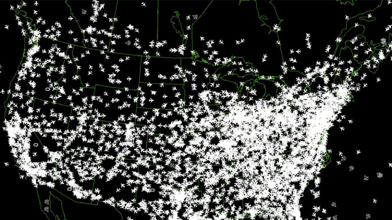 A map of the United States is densely overlaid with icons representing a large number of airplanes, depicting a high volume of air traffic across the country.