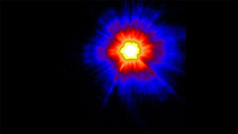 A thermal image showing a bright central heat source with red and blue heat patterns radiating outward.