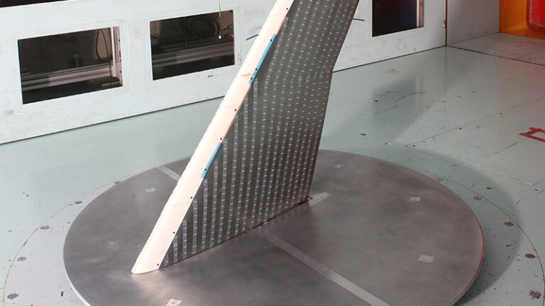 A solar panel stands on a round metal platform in a laboratory setting, demonstrating its structure and design elements.