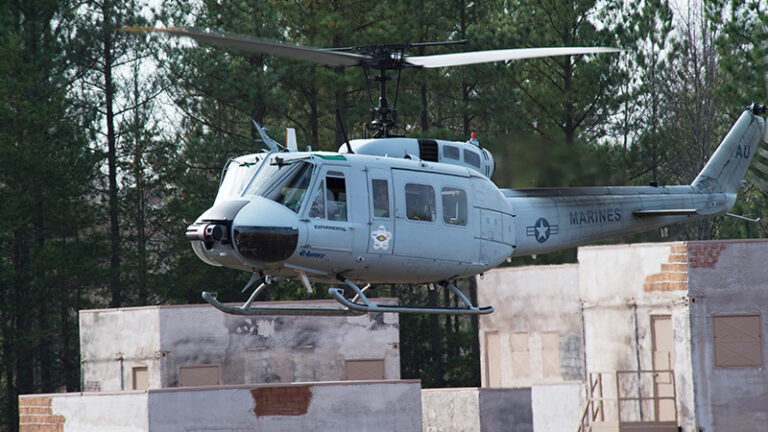 A u.s. marines helicopter landing on a rooftop in a training mockup town.