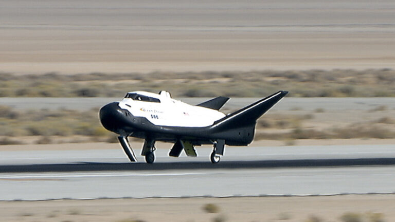 A spacecraft with an airplane-style design, featuring NASA's logo, lands smoothly on a runway in a desert area.