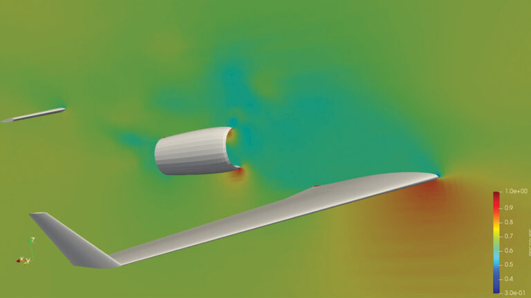 Computer simulation of airflow (color-coded by velocity) around an airplane wing and nacelle, with a gradient scale indicating velocity values on the right side of the image.