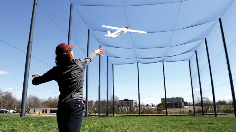 A person reaching for a model airplane.