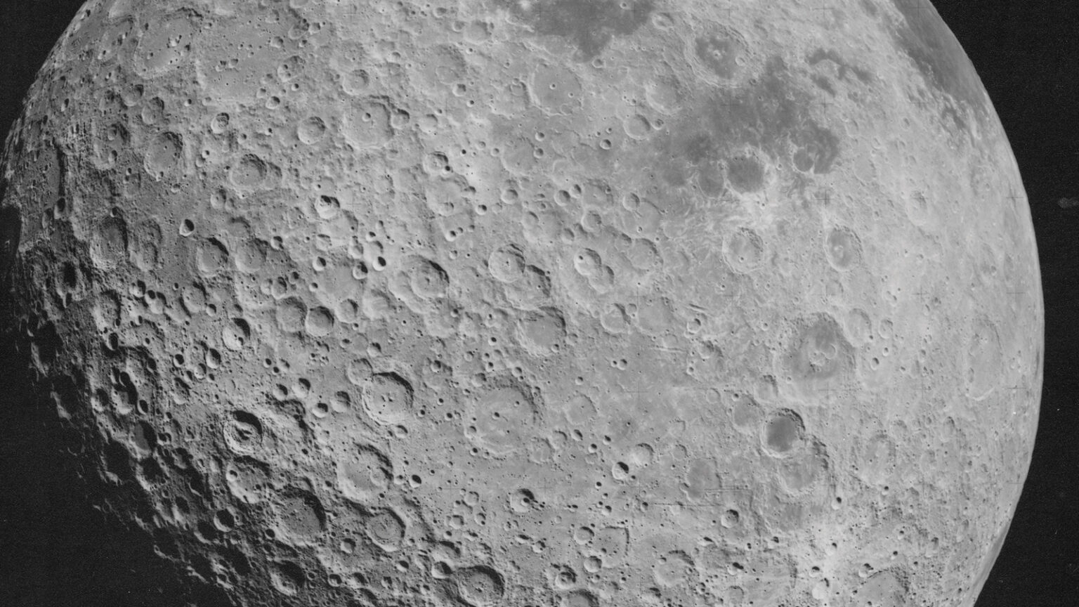 A detailed close-up image of the Moon's heavily cratered surface, showcasing numerous impact craters of varying sizes.