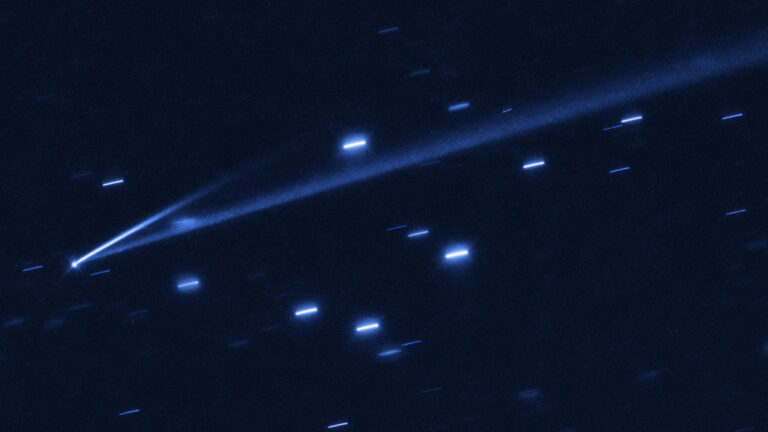 A bright comet with a long, glowing tail is seen streaking across a star-filled night sky.