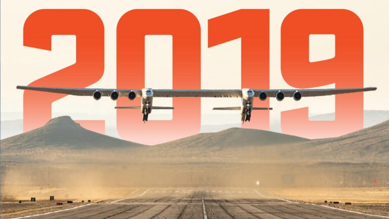 A large aircraft taking off from a runway with the year "2019" in bold red digits in the background.