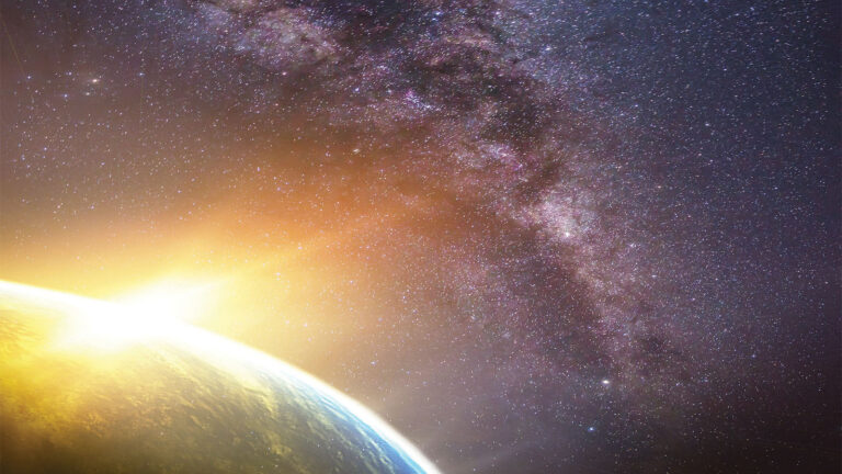 A view of Earth from space with the sun peeking over the horizon and the Milky Way galaxy visible in the background.