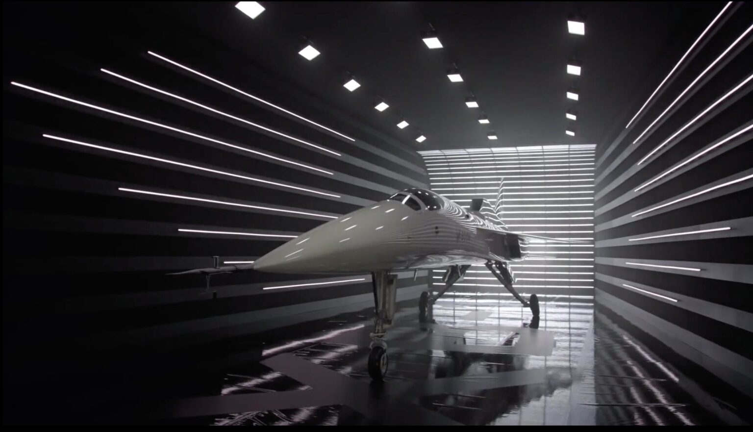 A sleek, futuristic aircraft displayed in a striped, illuminated hangar with reflective floors and walls.