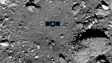 Aerial view of a gray, rocky surface with various sized rocks and pebbles. In the center, there is a small blue box icon with a crossed wrench and screwdriver symbol.