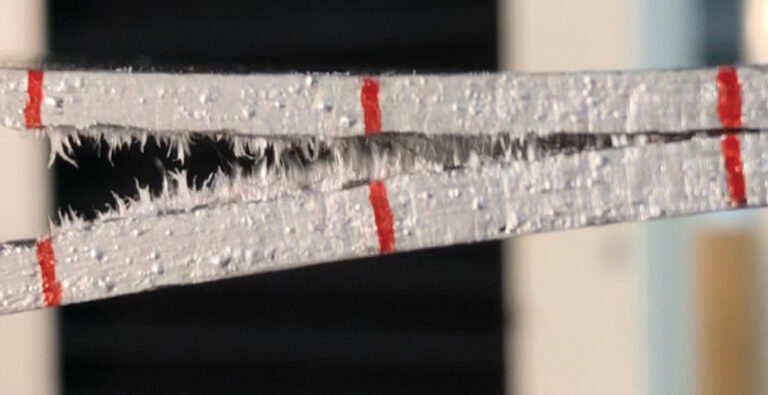 Probabilistic methods gain traction for designing complex systems Close-up of two halves of a cutting blade with jagged edges and three red markings on a blurred background.