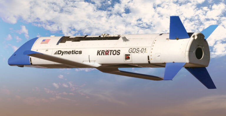 A white and blue aerial drone with the labels "Dynetics," "KRATOS," and "GDS-01," shown against a background of clouds and sky.