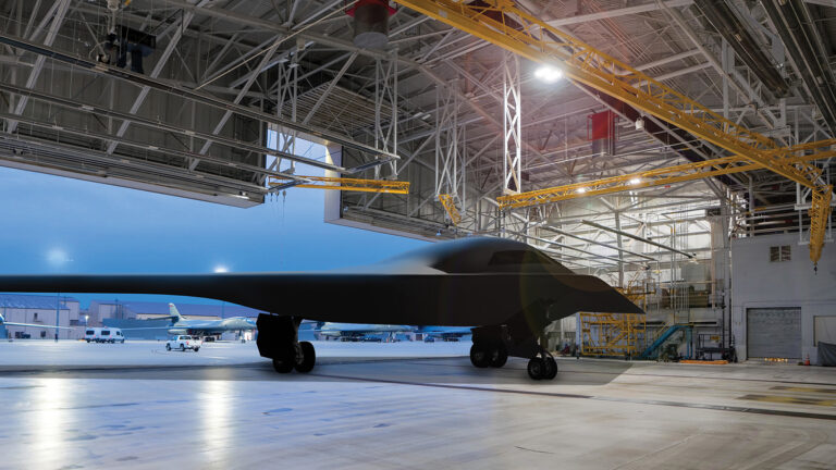 New architectures, agile development and next-gen rad-hardening lead work in computing A stealth aircraft is parked inside a large, well-lit hangar with industrial equipment and open space in the background.