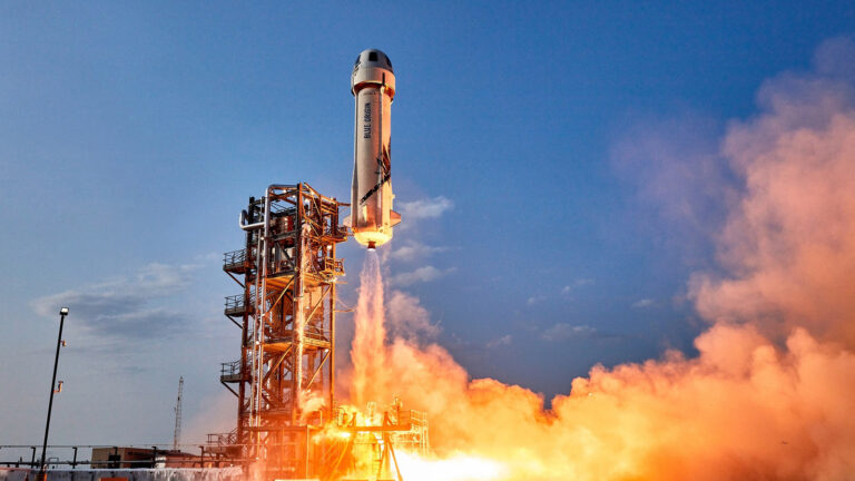 A rocket launches into the sky, emitting a large plume of orange smoke and flames.