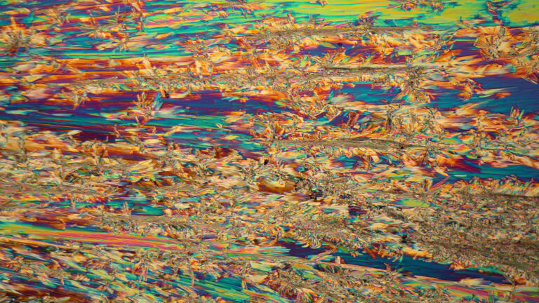 A colorful, abstract pattern featuring swirling and jagged lines in shades of orange, blue, green, and yellow.