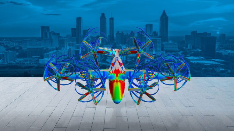 A colorful multirotor drone is shown hovering above a paved surface with a cityscape visible in the background.
