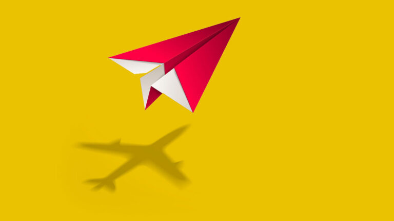 Red paper airplane casting a shadow shaped like a real airplane on a bright yellow background.