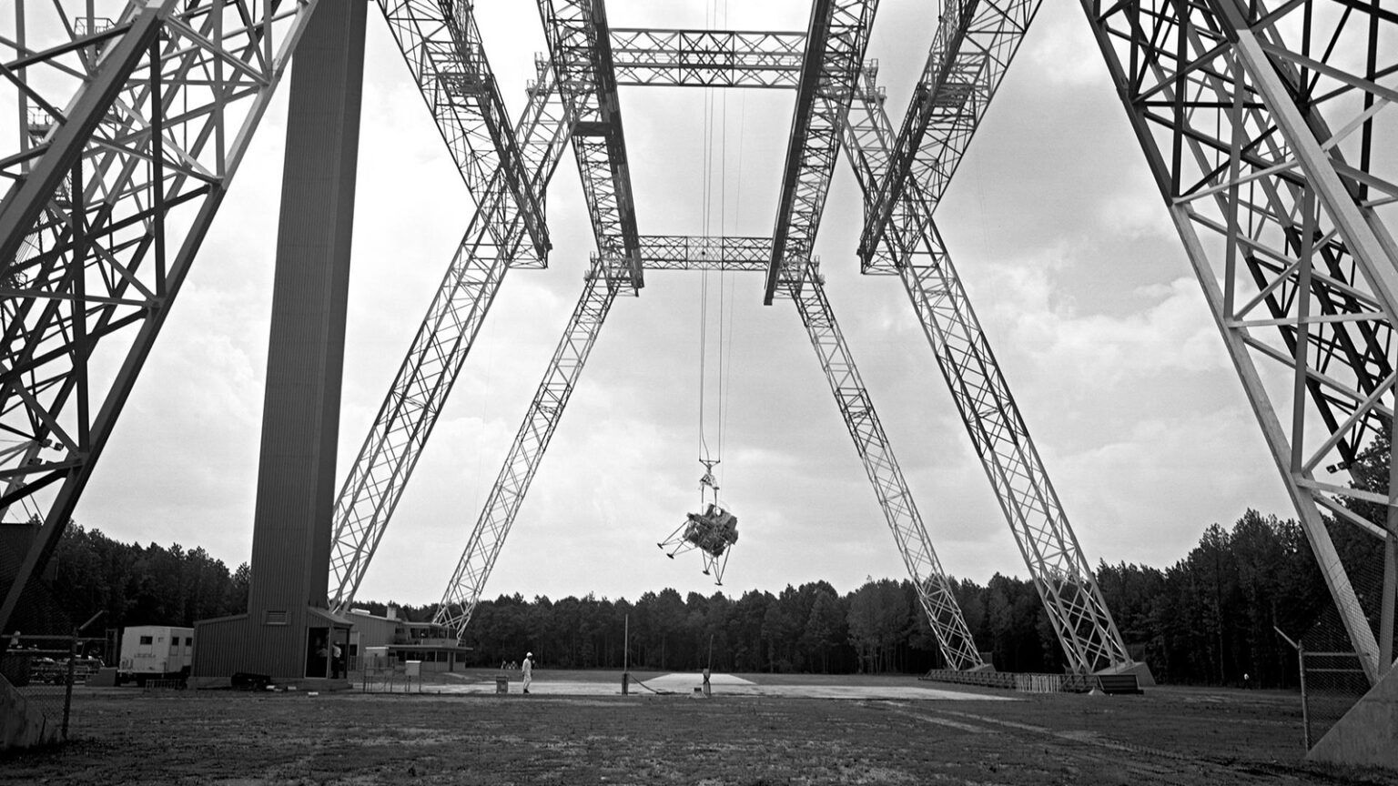 A lunar lander prototype is suspended by cables from a large gantry structure at NASA’s Langley Research Center.