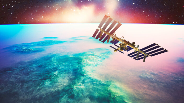Image of the International Space Station orbiting above Earth, with a backdrop of space and a vibrant sunrise or sunset horizon.