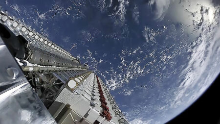 A satellite orbits above Earth, showcasing a view of the planet's surface and atmosphere with structured arrays pointing toward space.