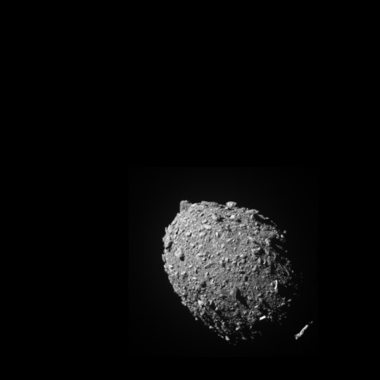 Close-up image of an asteroid, showcasing its rocky and uneven surface against a black background.