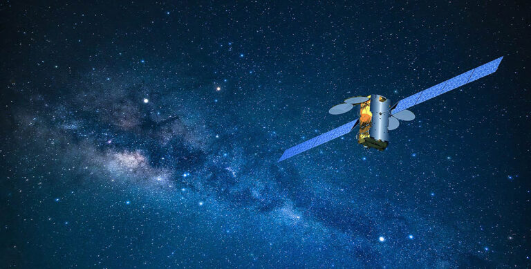 Satellite orbiting in outer space against a backdrop of a starry sky and the Milky Way galaxy.