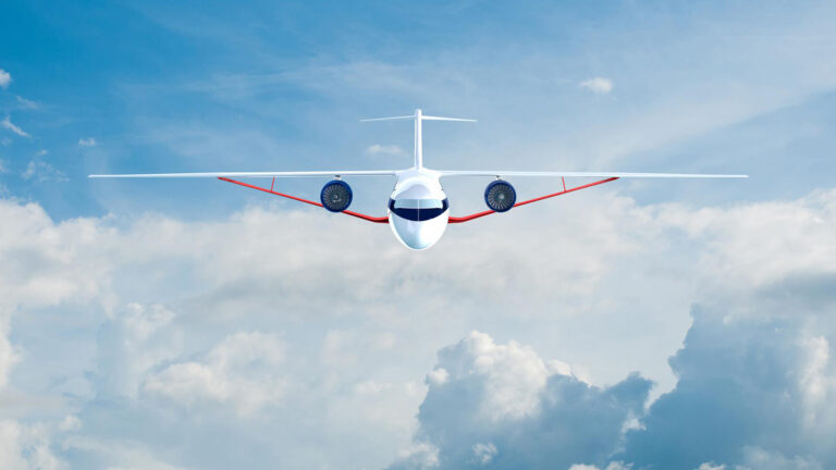 A white airplane with red accents flying directly towards the camera through a partly cloudy sky.