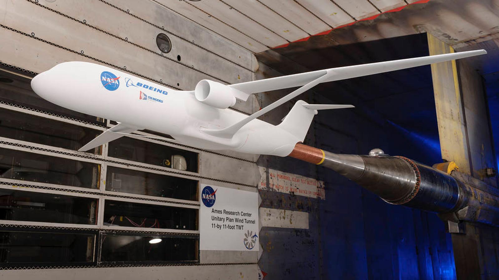 Model of an aircraft with NASA and Boeing logos in a wind tunnel at NASA Ames Research Center.