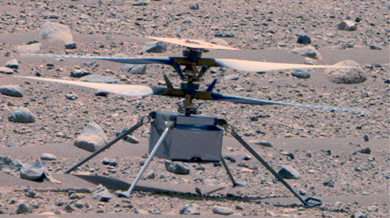 A small helicopter-like drone with large propellers is stationed on a rocky, barren surface.