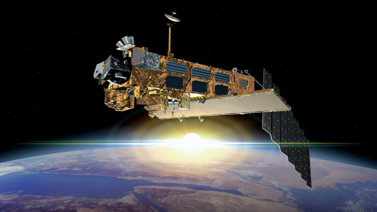 A satellite in outer space with solar panels extends above Earth, with the planet and its horizon visible in the background illuminated by the sun.