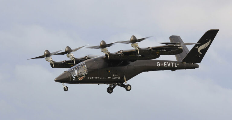 A black Vertical Aerospace eVTOL aircraft, model VX4, with six propellers flying in the sky.