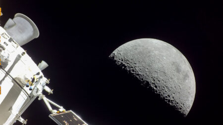 Close-up view of the moon's surface with a spacecraft's equipment in the foreground against a dark space background.