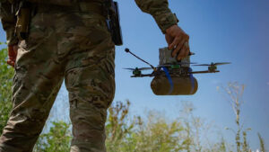 Closeup of a Ukrainian serviceman holding a small drone