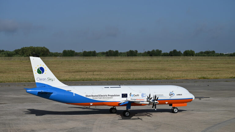A small aircraft with "Clean Sky 2" branding is parked on a runway, featuring distributed electric propulsion technology.
