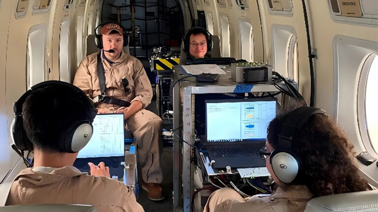 Quantum sensing moves closer to reality Four people in headsets sit inside an aircraft, monitoring data on laptops and equipment.