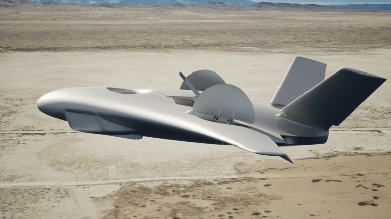 A futuristic, silver drone with a sleek design and vertical stabilizers is flying over a desert landscape.