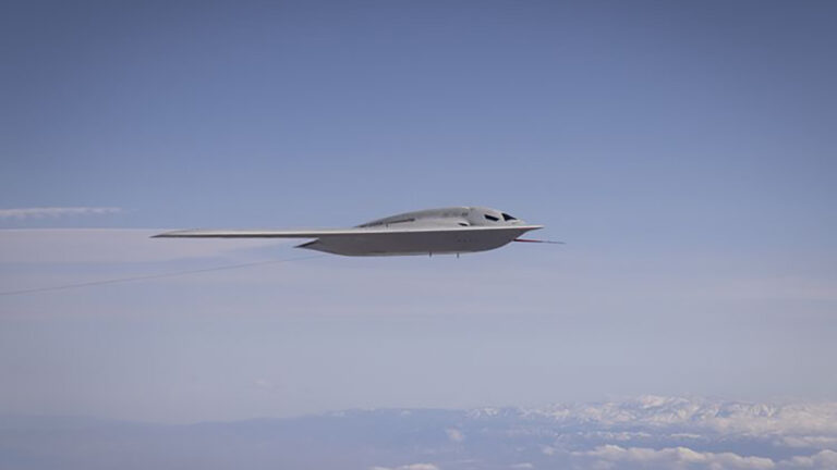 Stealth aircraft flying in a clear blue sky with distant mountains visible below.